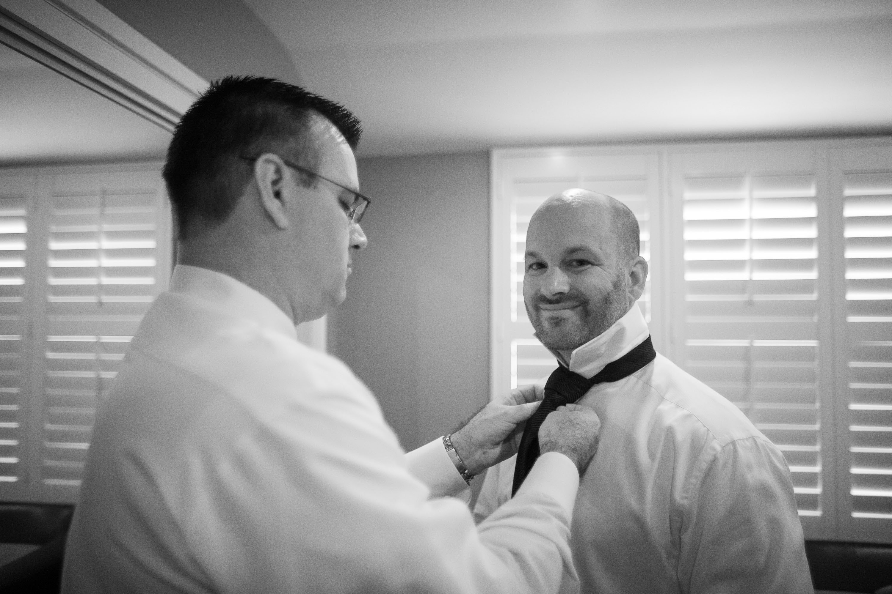 The best man helps the groom with his tie at the Garden Court Hotel in Palo Alto