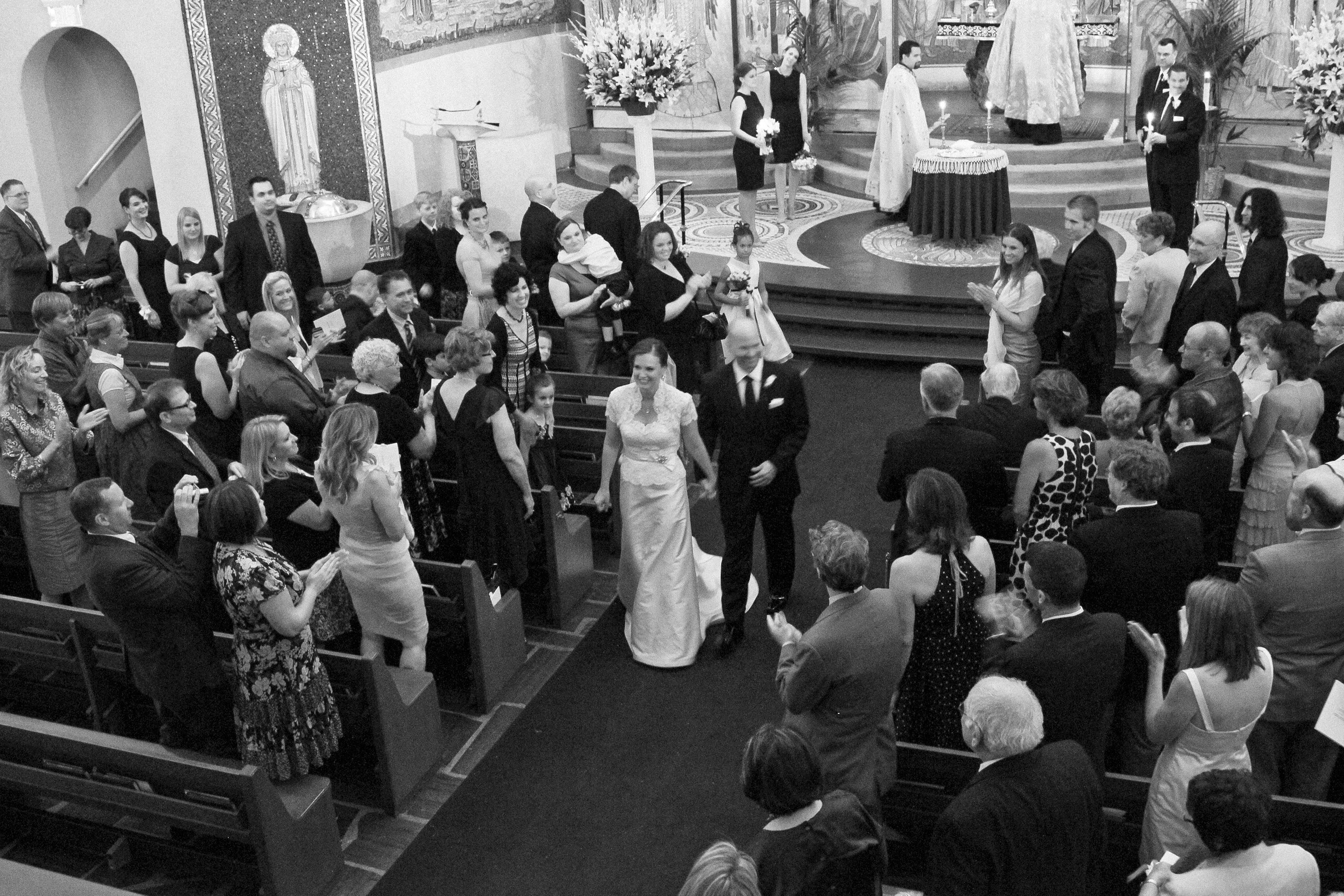 View from the balcony as the bride and groom process down the aisle,  at the Holy Cross Greek Orthodox Church in Belmont