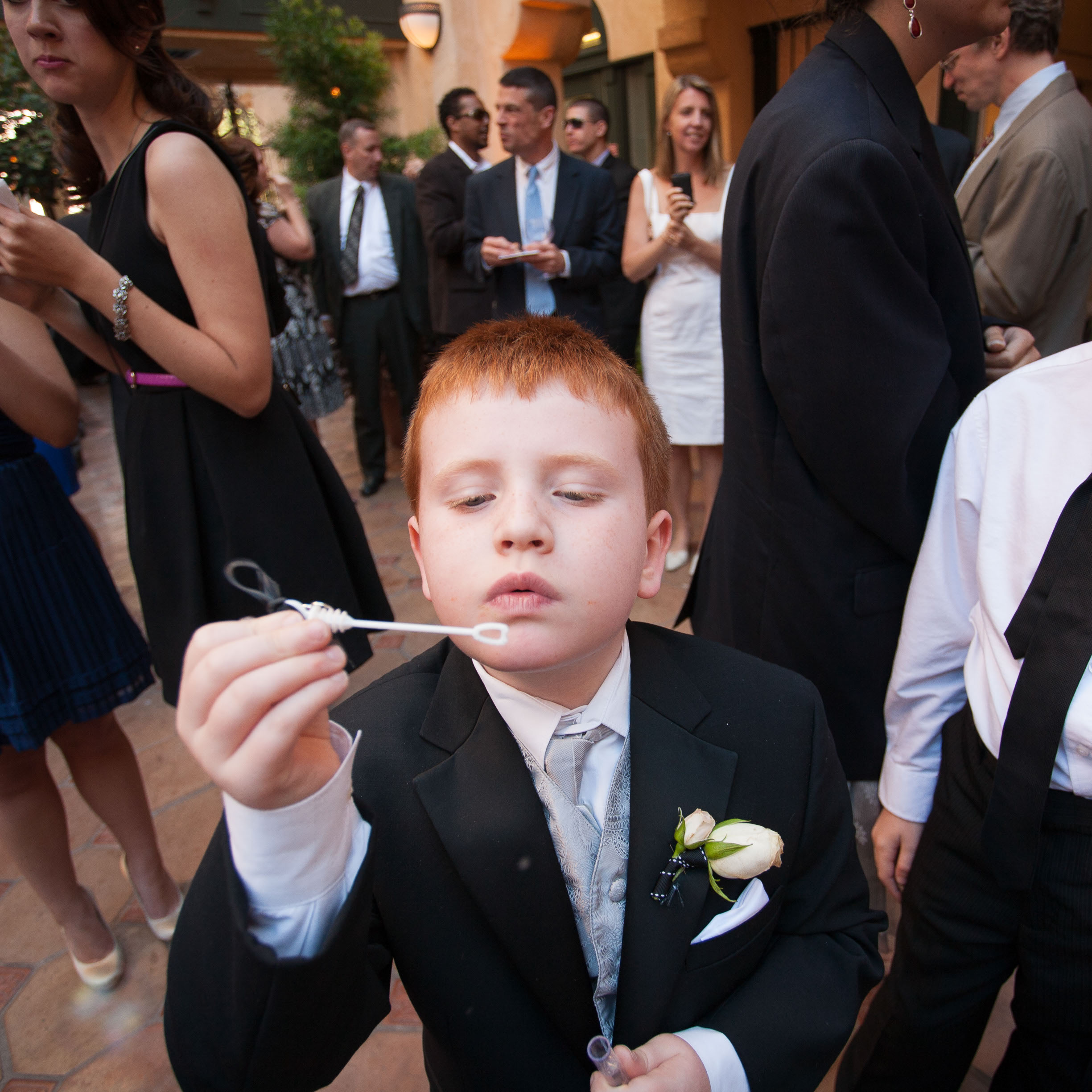 A young man with bright red hair blows bubbles  at the Garden Court Hotel in Palo Alto