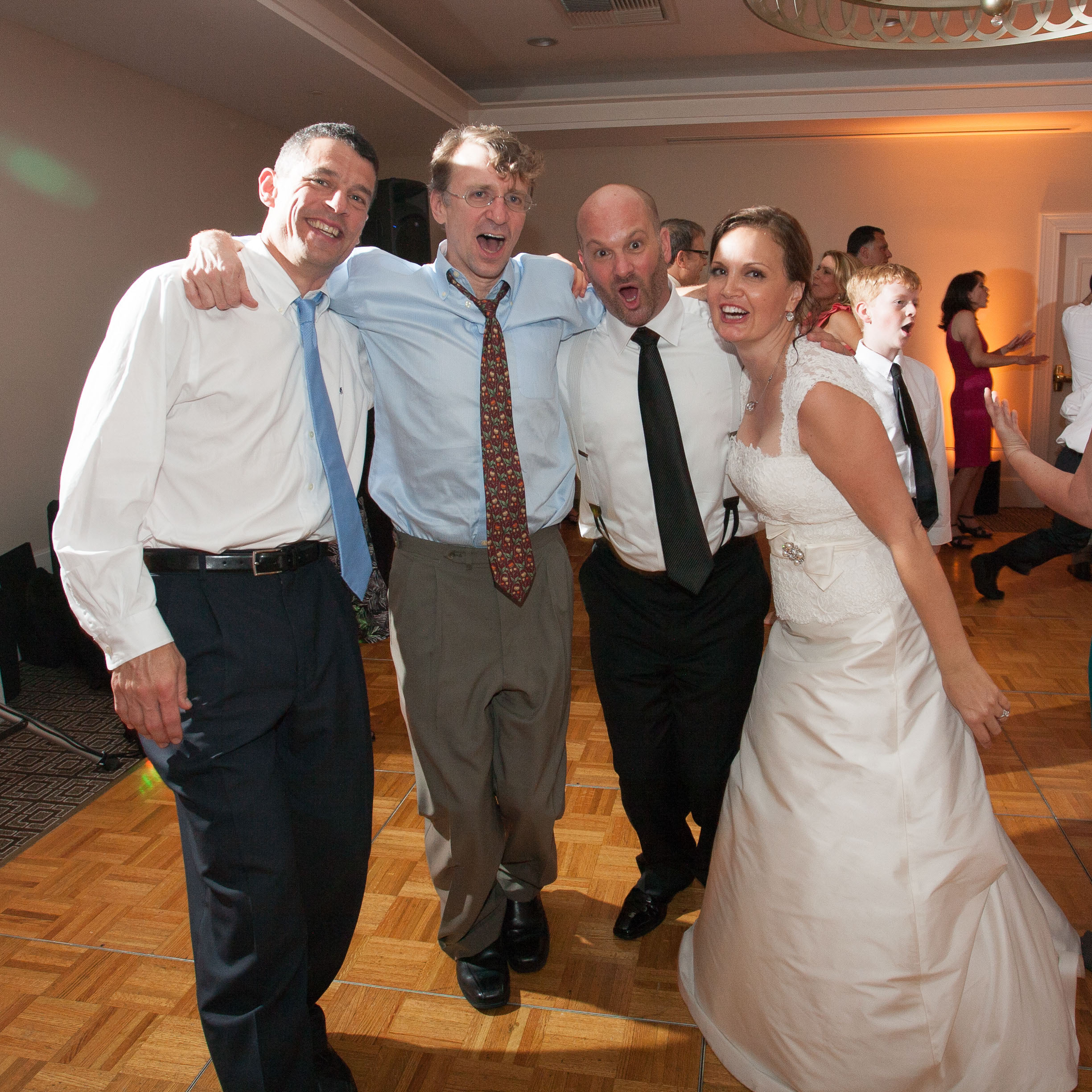 The bride and groom embrace their friends as they dance at the Garden Court Hotel in Palo Alto