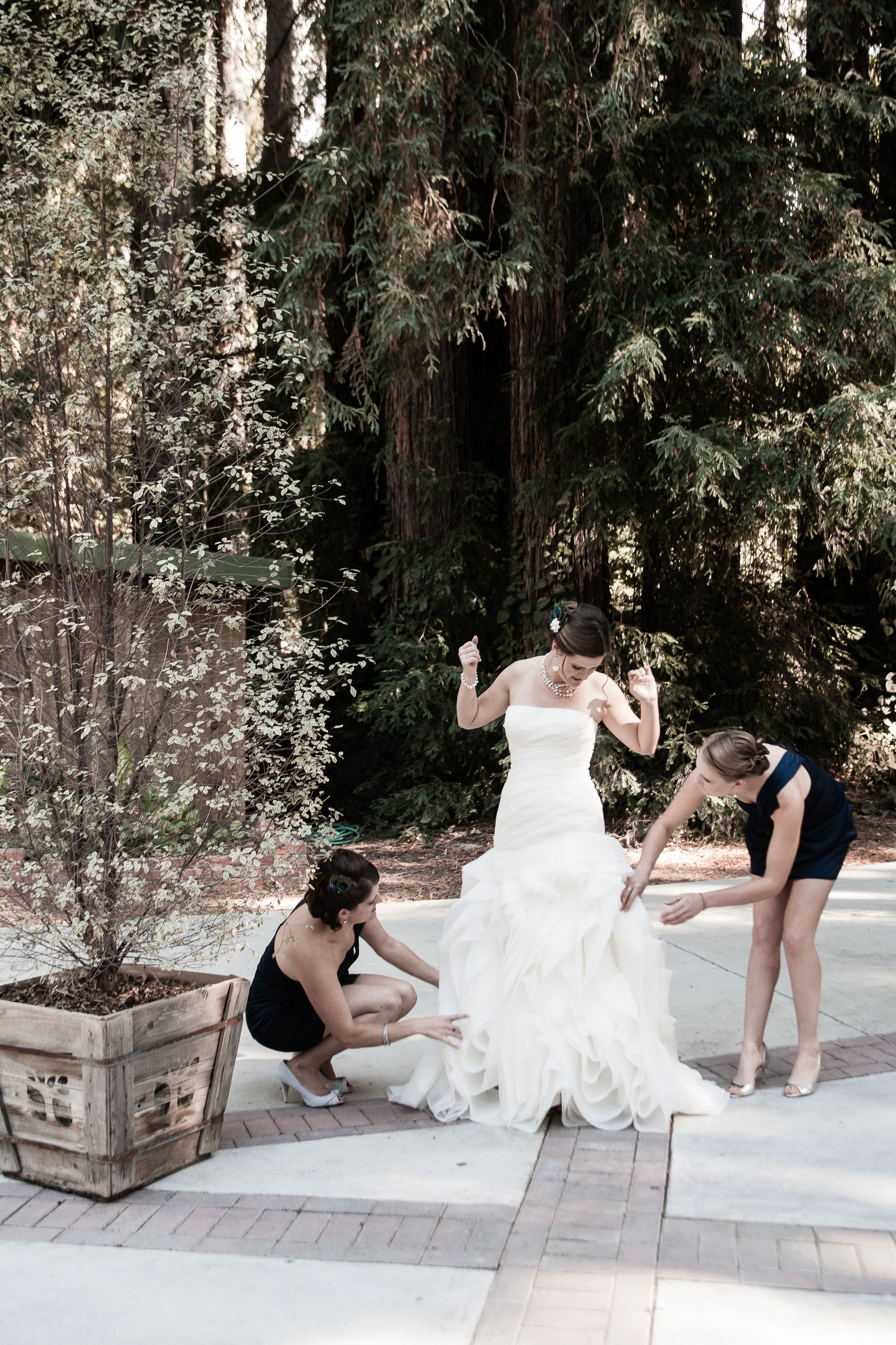 Bridesmaids add finishing touches to Carlie's Vera Wang gown at Pema Osel Ling in the Santa Cruz mountains