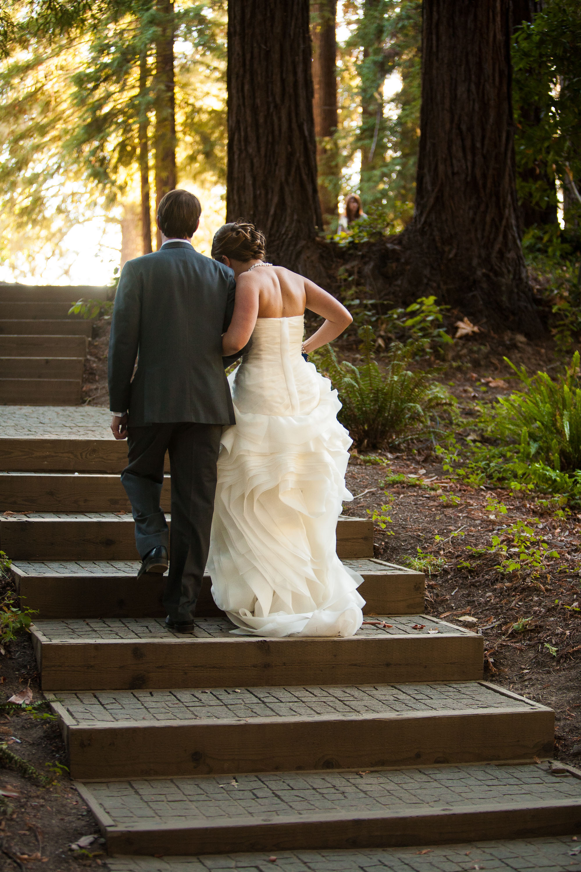 A newly married couple strolls into a gorgeous sun dappled forest at Pema Osel Ling in the Santa Cruz mountains