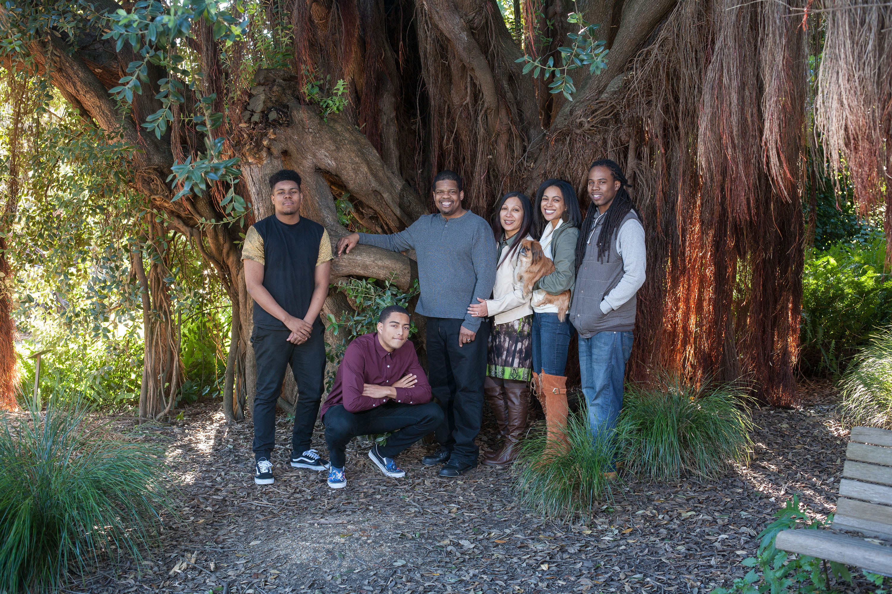 A portrat of an African American family under a beautiful tree.