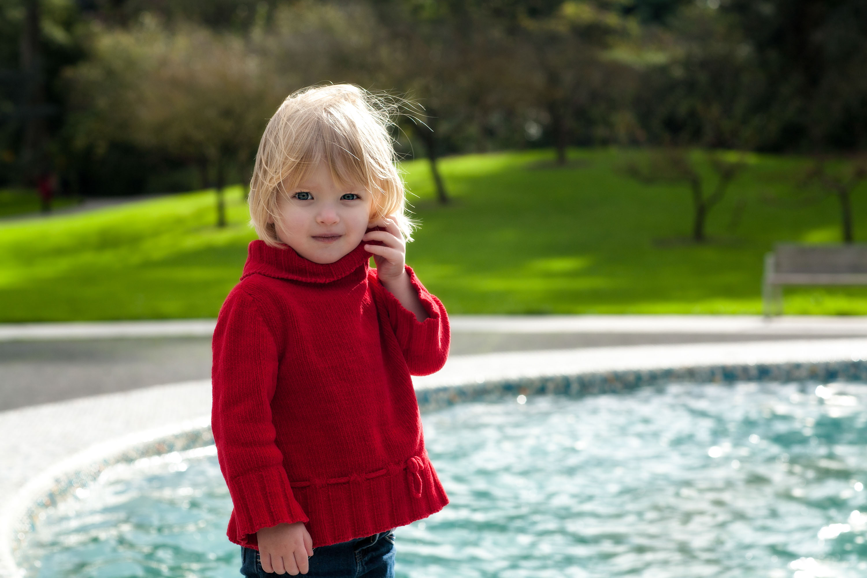 Stunning portrait of a 4-year-old in a red sweater at the San Francisco Botanical Garden.