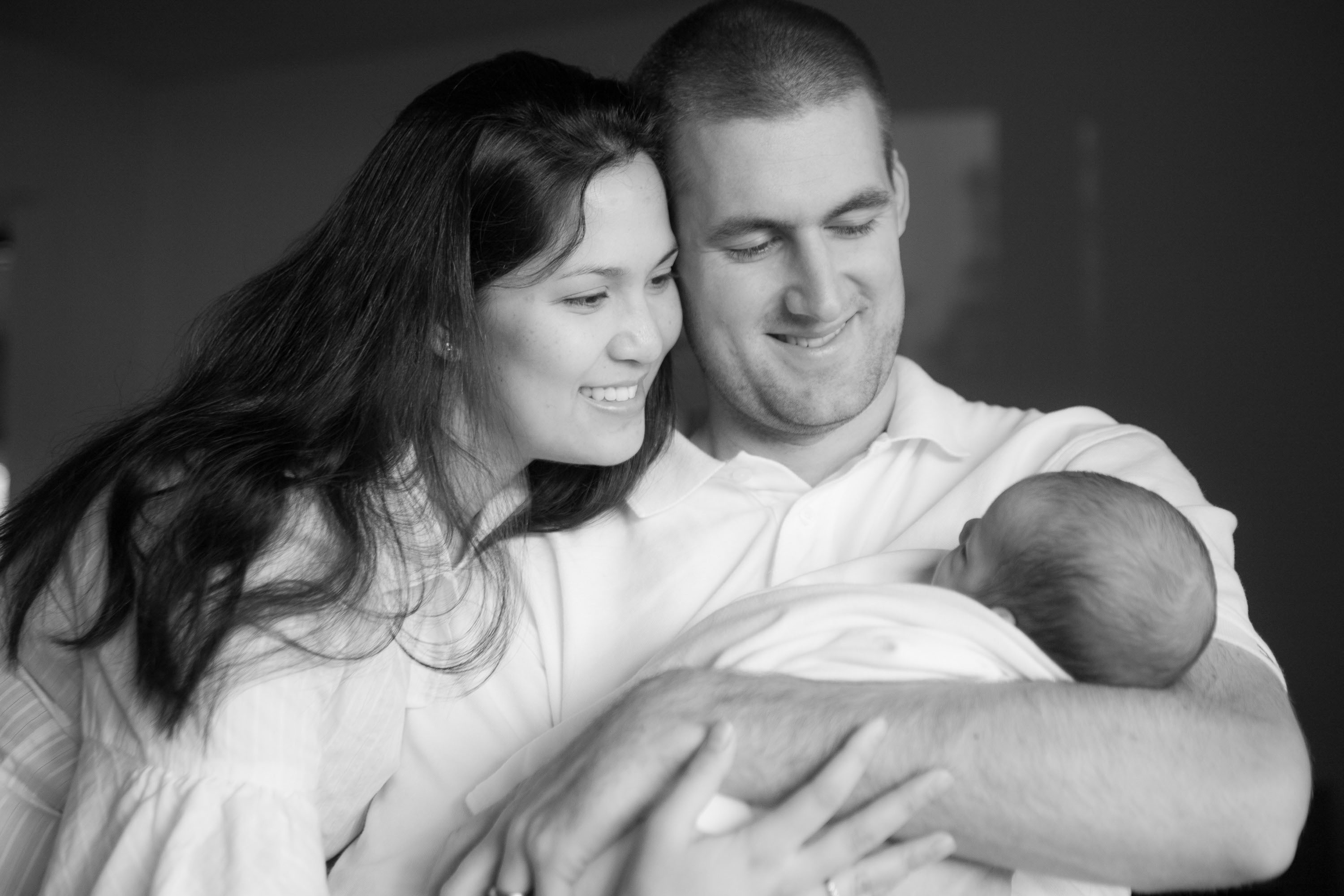 A sensitive black and white portrait of a couple with their new baby.