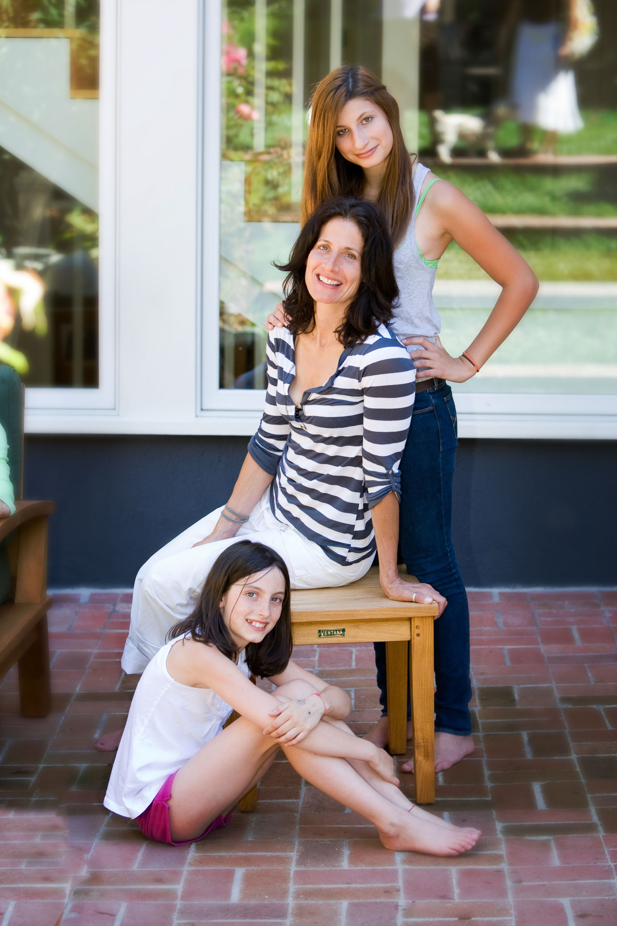 A relaxed back-yard portrait of a mom and her two teen daughters, made in Marin.