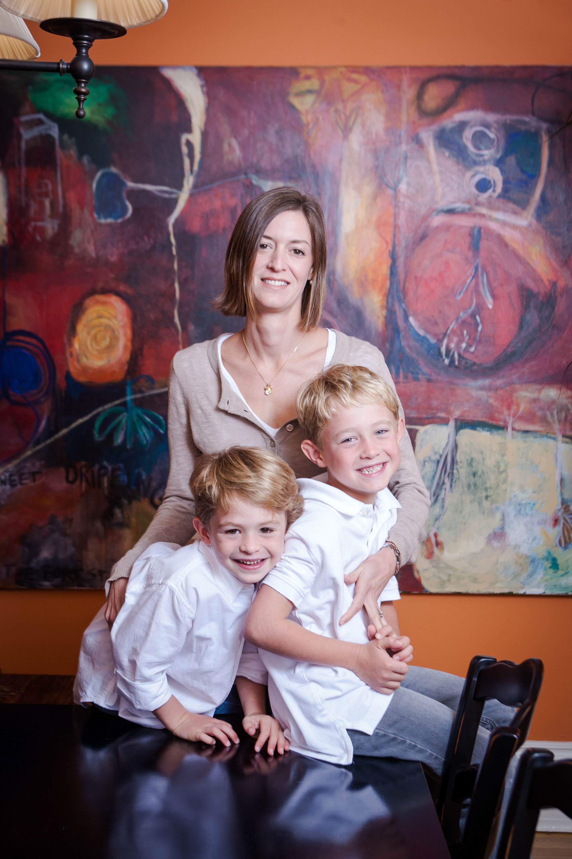 A mom poses with her two fiesty boys in their beautiful San Francisco dining room.
