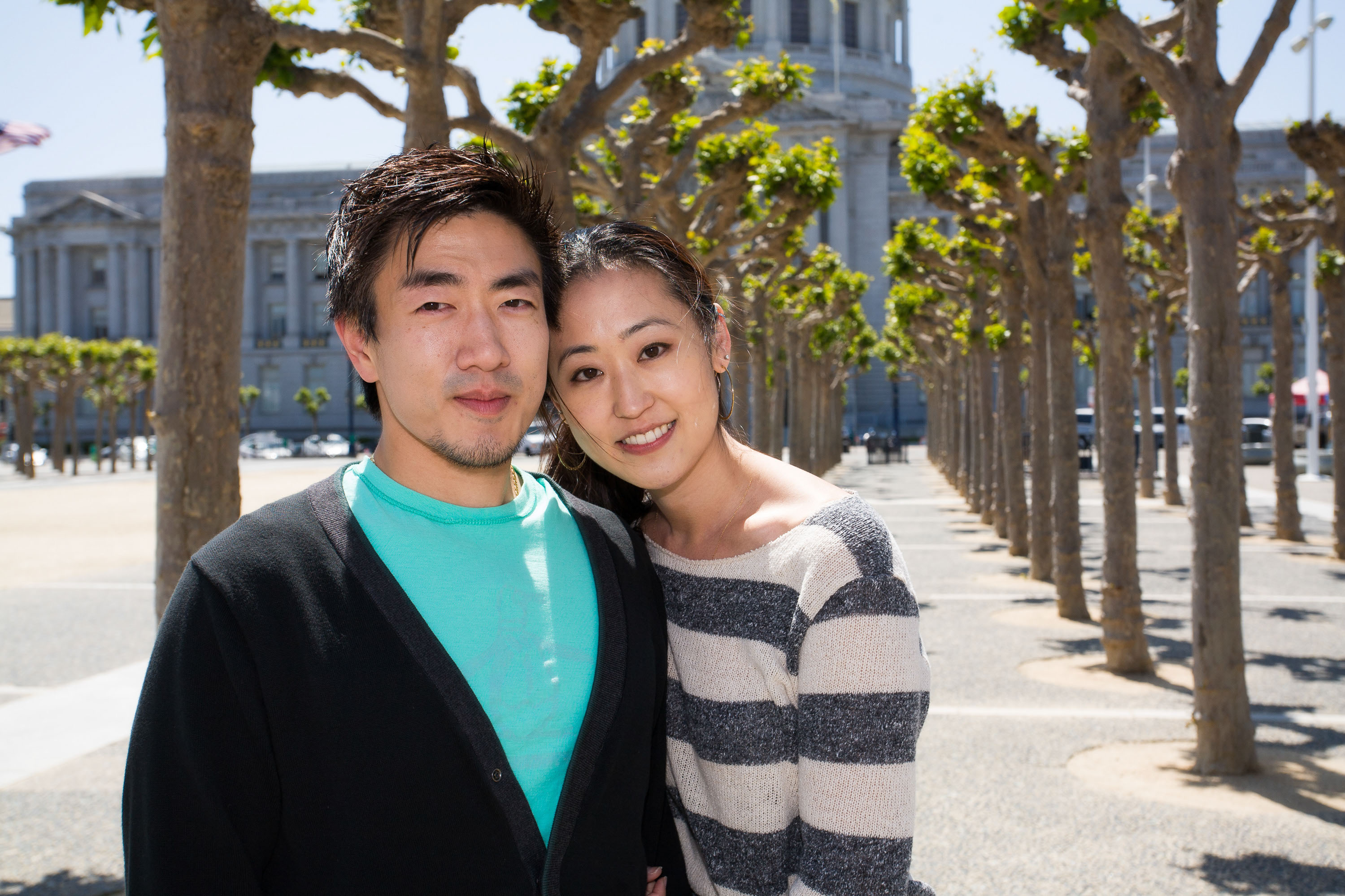 A simple modern bridal portrait framed by the collonnade of trees in front of San Francisco City Hall