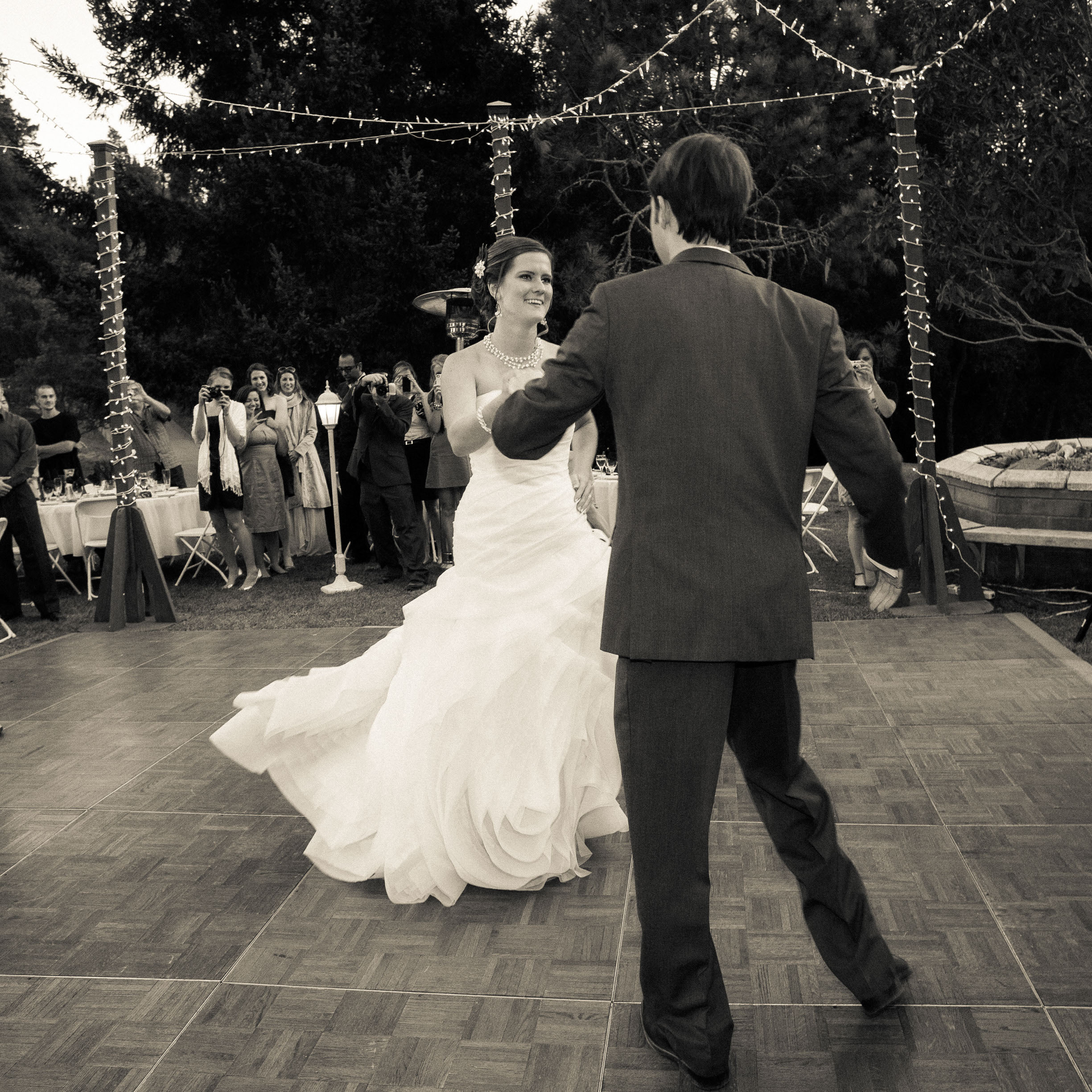 A classic black & white of the bride spinning in her Vera Wang Gown during the first dance at Pema Osel Ling Retreat Center in Santa Cruz