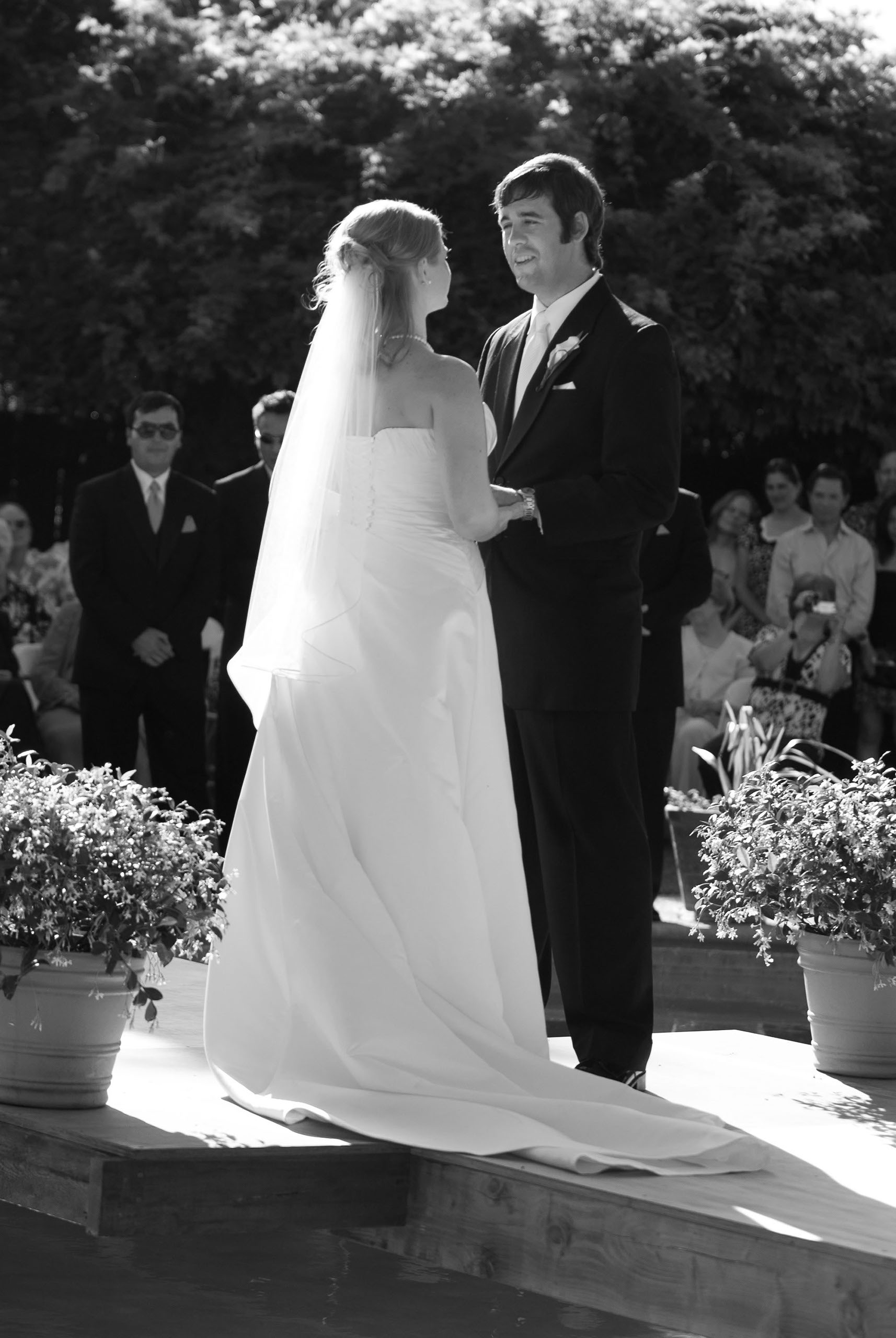 Classic black & white ceremony candid as the groom looks into the bride's eyes, at a private home in central California