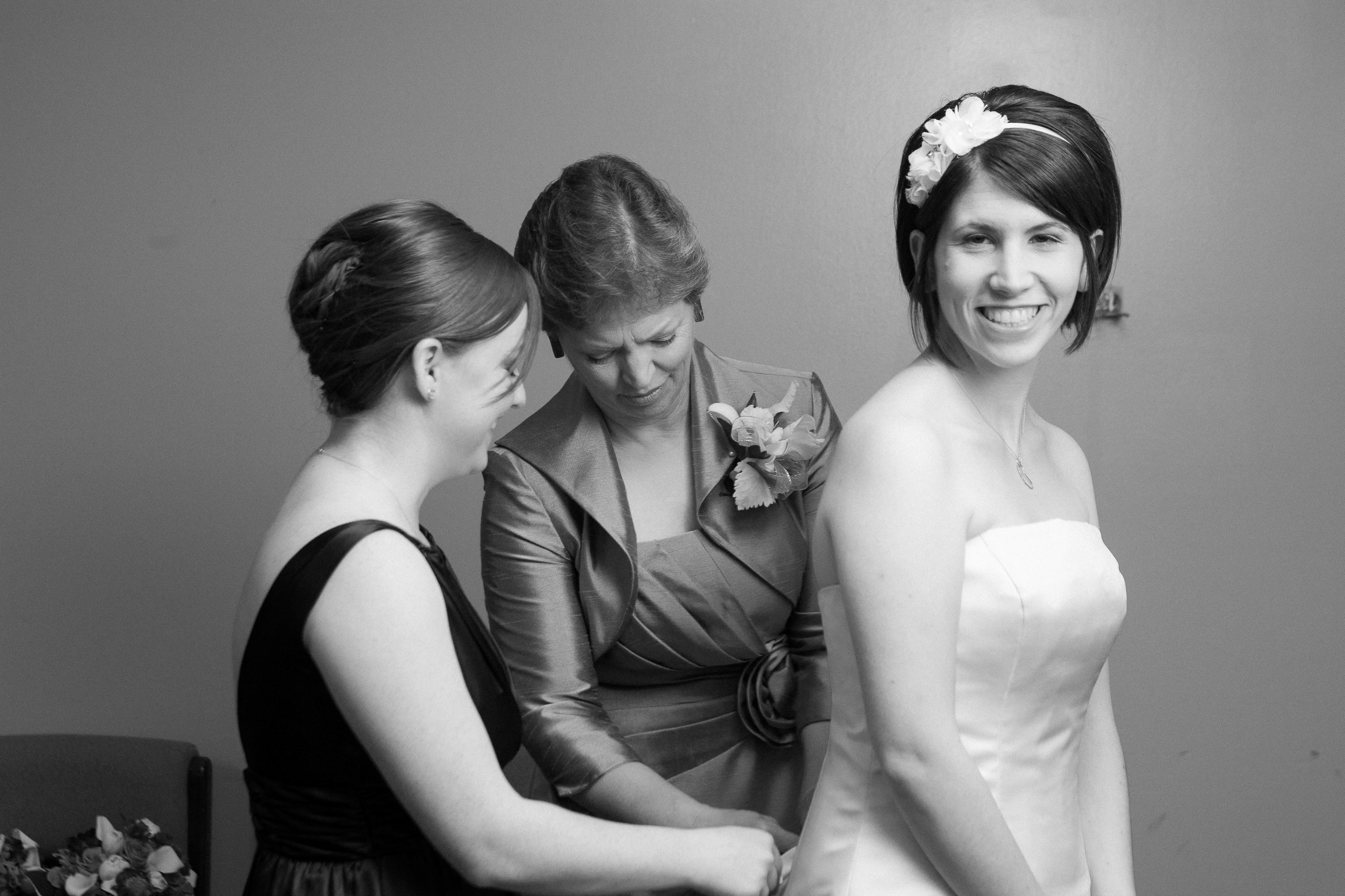 Her maid of honor and her mom put the finishing touches on a bride's dress, at St. Mary's Cathedral in San Francisco.